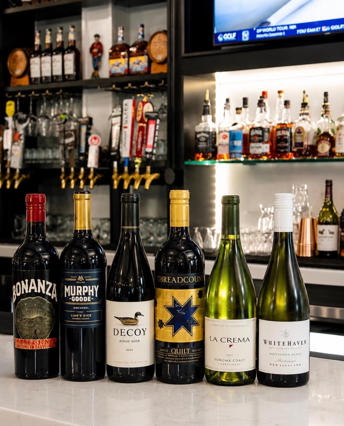 The full service bar at Fairways at GLC, stocked with wine, beer taps, and spirits